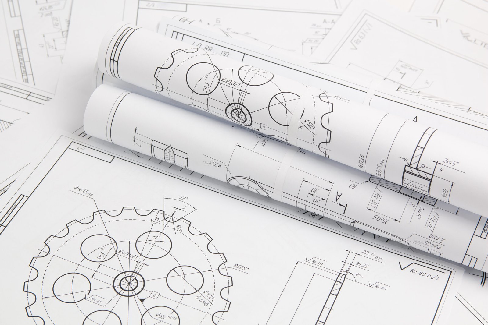 Rolled engineering blueprints with gear drawings